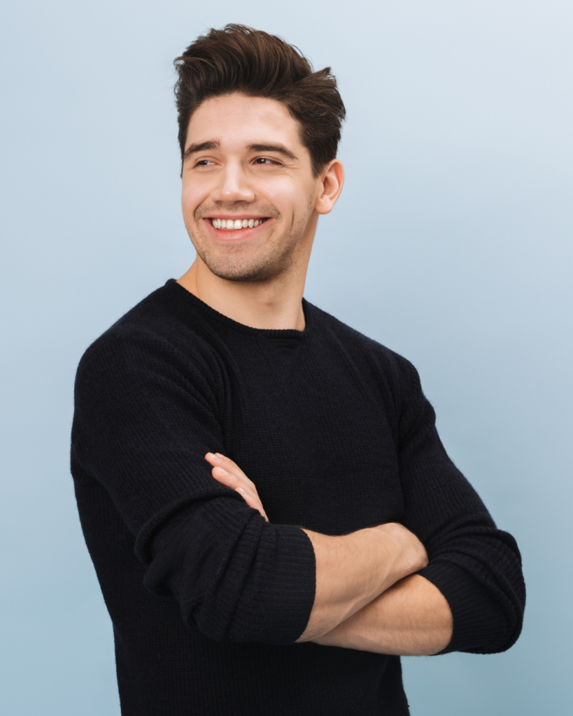 A young man smiling confidently after replacing metal fillings with composite.