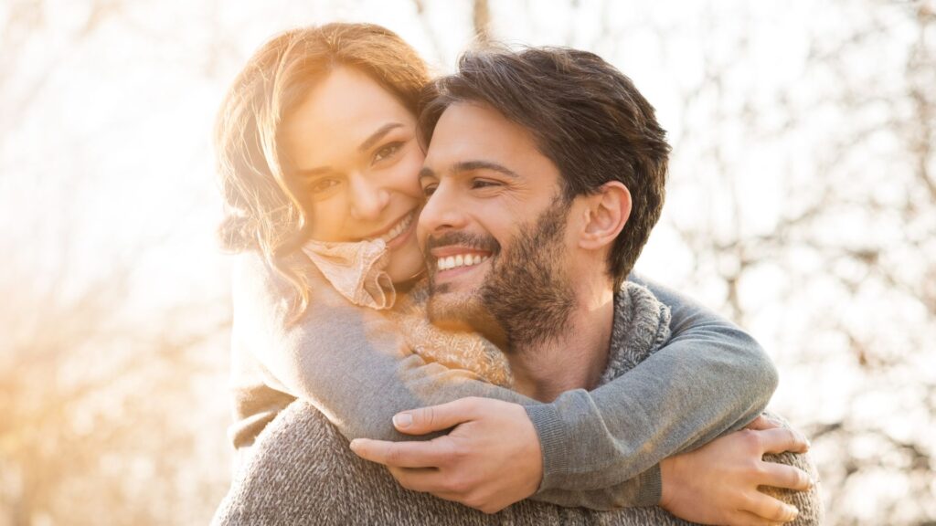 A young couple smiling, both relaxed and at ease after sedation dentistry.