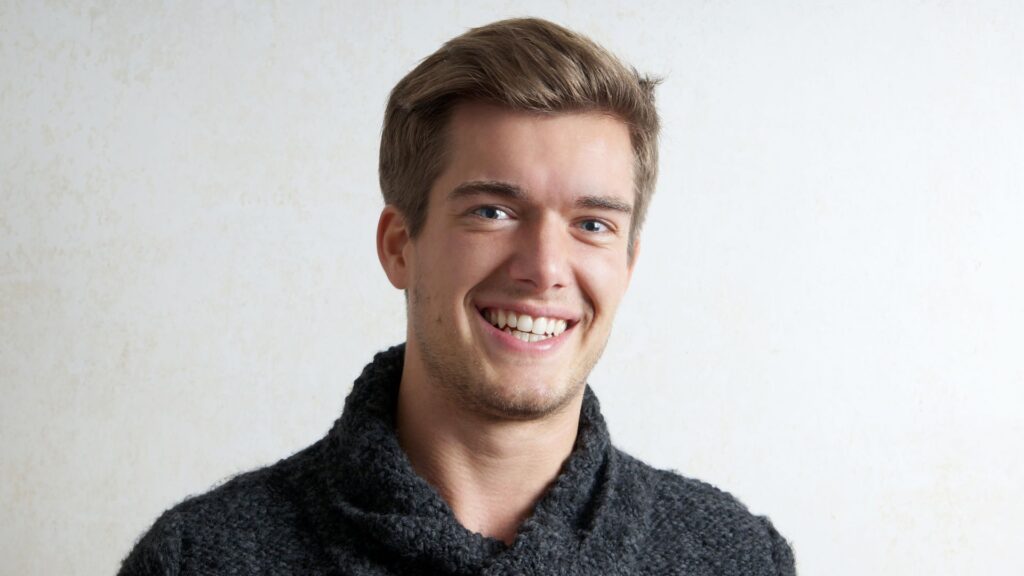 A young man smiling confidently thanks to clear aligners in OKC.