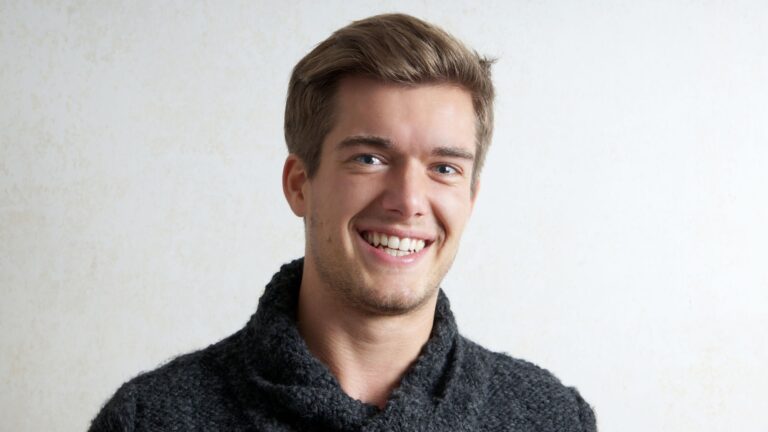A young man smiling confidently thanks to clear aligners in OKC.